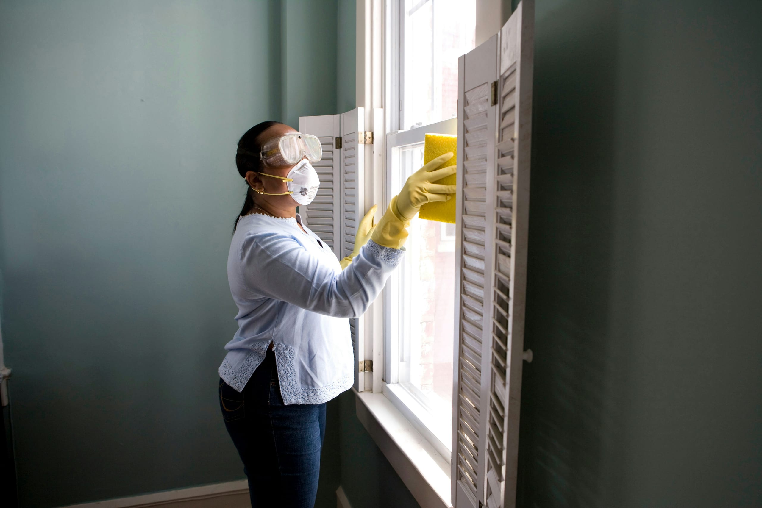 A Bravo Cleaning professional detailing a window frame