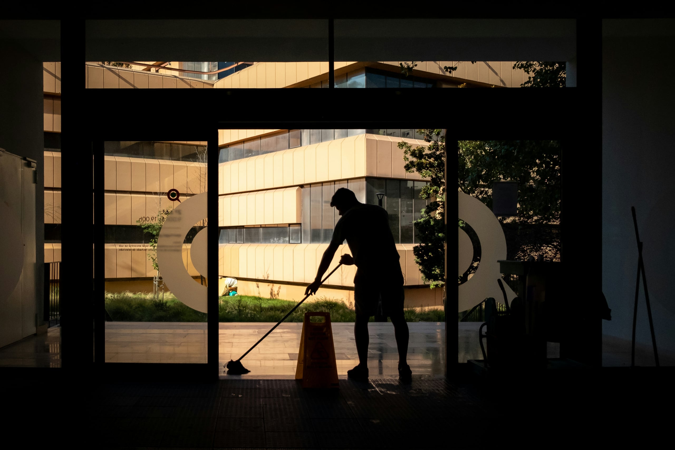 A Bravo cleaner mopping a lobby floor in early morning light