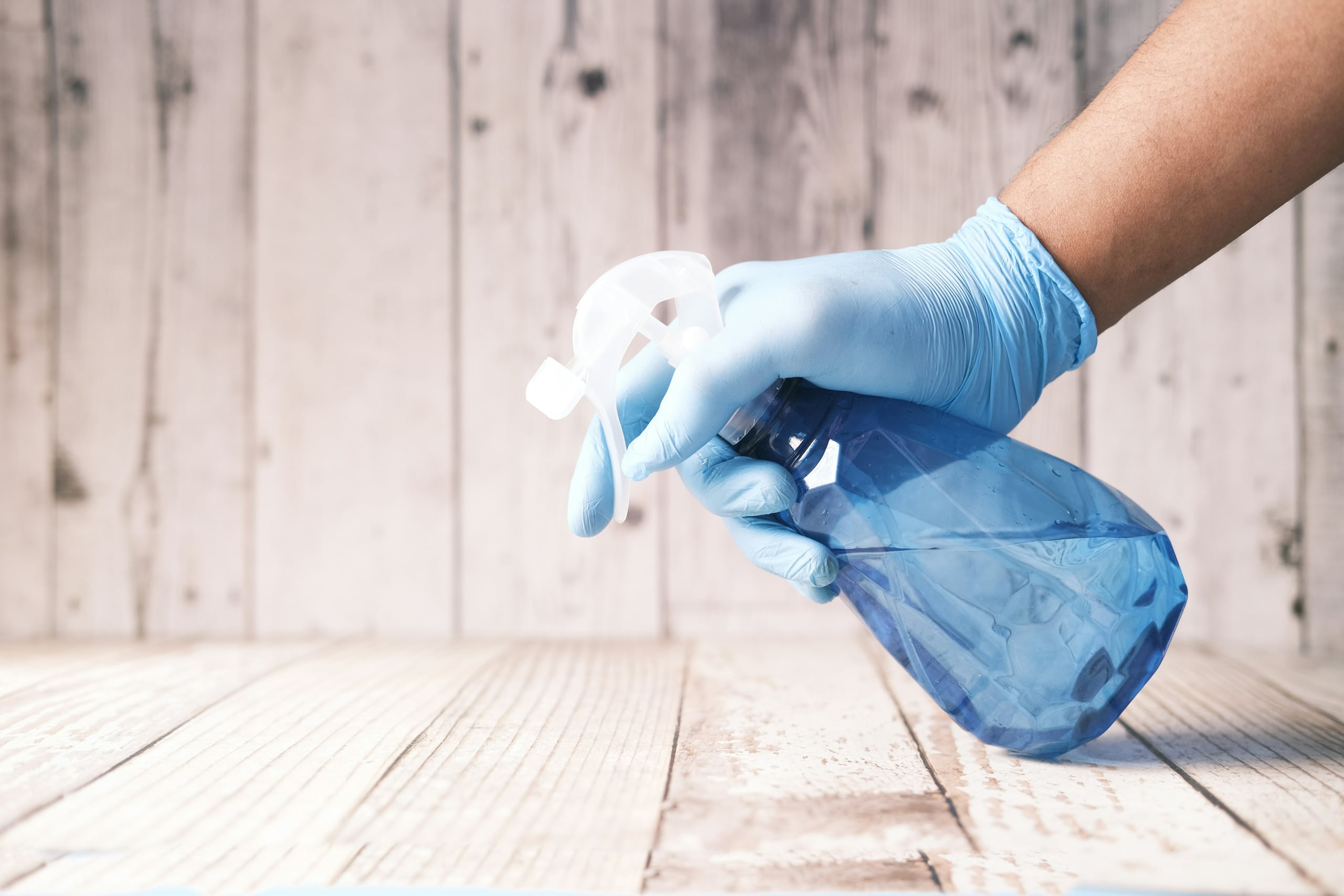 A gloved hand applying eco-friendly cleaning spray